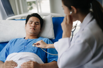 Obraz premium Asian doctor in white suit take notes while discussing and Asian elderly, man patient who lying on bed with receiving saline solution in hospital or clinic..
