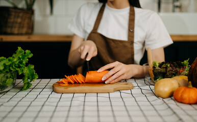 beautiful adult woman while making salad at open kitchen. healthy food concept..