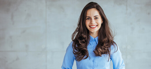 Portrait of beautiful confident smiling businesswoman standing with arms crossed in the office and...