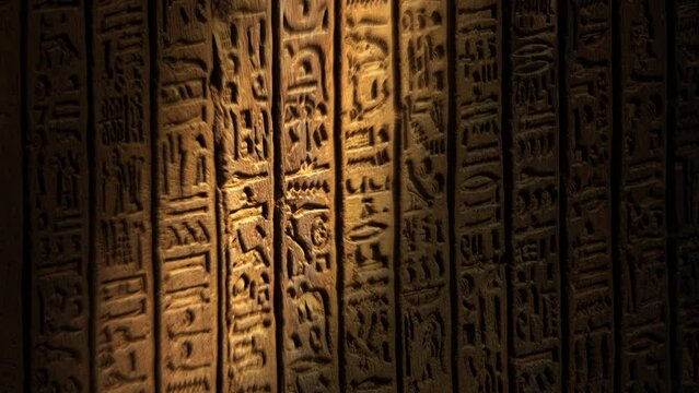 Light spot moving on ancient egypt hieroglyphics carving on wall of temple, 4k