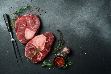 Fresh veal meat osso buco shank steak, italian ossobuco. Black background. Top view. Copy space