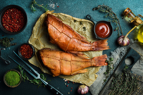 Smoked fish red sea bass. Sea bass closeup. Delicious seafood for proper nutrition. On a black background. Free space for the recipe.