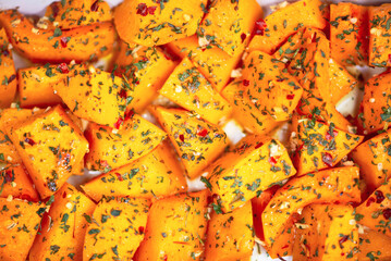 pumpkin pieces with spices in a baking dish in the oven