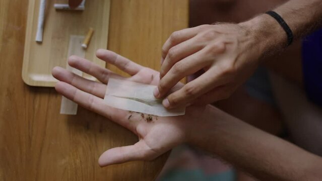 Close up of man hands rolling a joint