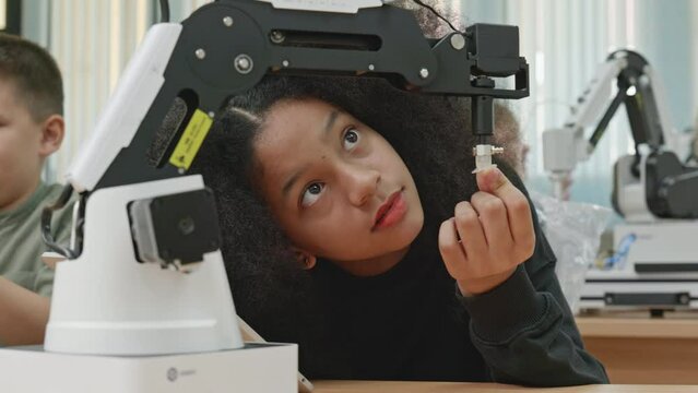 Group Kid teen child enjoy Machine Learning Robot arm is Moving Under coding Control robot at stem technology class, stem education for digital automation learn for use artificial intelligence ai