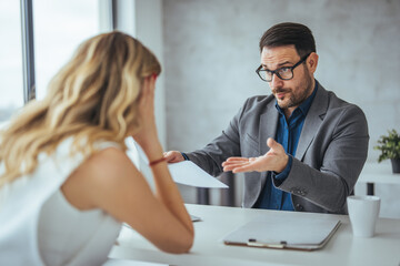 Angry businessman arguing with businesswoman about paperwork failure at workplace, executives...