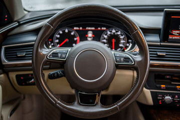 Steering wheel, speedometer, display, and multimedia dashboard. Luxury modern car interior business...