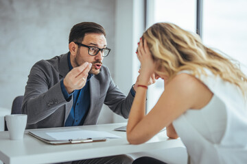 Boss threatening with finger his employee in office. Angry mean boss yelling at employee for...