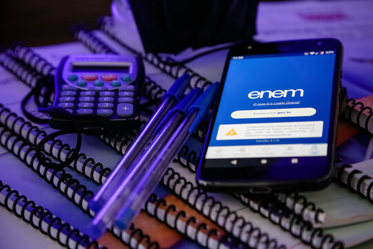 Aplicativo do Enem estudo na m&atilde;o com caneta e caderno.