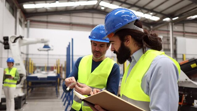 Male coworkers in the robotics factory discuss the benefits and challenges of automation, emphasizing the need for ongoing training and collaboration.