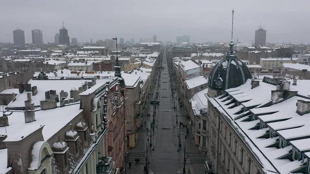 Aerial winter cityscape of Lodz, Poland. View along the famous tourist attraction - Piotrkowska Street with rooftops covered in snow.
