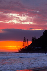 Beach view with colourful ocean sunrise and clouds over Burleigh Headland, Gold Coast Australia