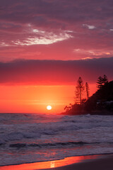 Beach view with colourful ocean sunrise and clouds over Burleigh Headland, Gold Coast Australia