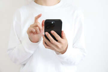スマートフォンを触る女性の手元