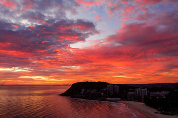 Sunlit pink clouds over Burleigh Headland and beach. Gold Coast, Australia