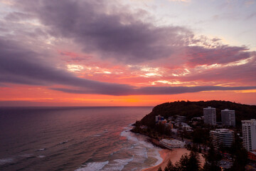 Sunlit pink clouds over Burleigh Headland and beach. Gold Coast, Australia