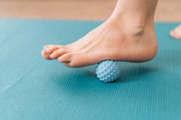 Lady kneading her feet with myo fascial release ball.