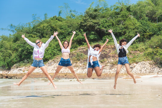 Group of diverse teenager friends jumping on the beach, They enjoying on vacation summer, Travel concept.