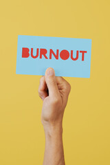 man holding a sign with the text burnout