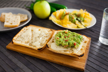 toasted slices of square bread with warm cheese and homemade guacamole on plate for healthy breakfast