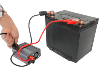 connecting a network wire to a power inverter, connected to a 12v battery, a DC to AC converter, on an isolated white background