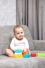 Naklejka premium baby girl playing with colorful toy blocks