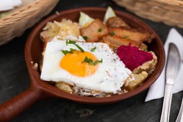 Scrambled eggs with fried bacon and potatoes served on plate