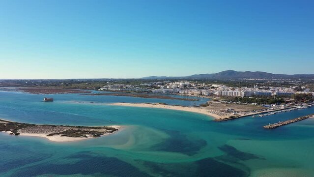 Aerial view. Drone flight over the natural Portuguese park Ria formosa over the village of Fuseta. Clear turquoise water with sand dunes