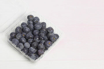 Large blueberries in a decorative container. International day without diets. On a white background. Close-up.