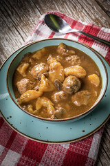 Meatballs in gravy with cast noodles.