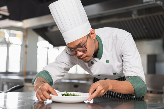 Asia teenager chef prepare food on dish at kitchen