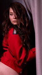 Girl in a red jacket on a light background