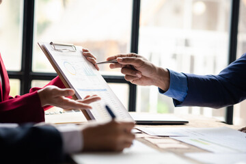 The sales department is having a monthly summary meeting to bring it to the department manager, they are verifying the correctness of the documents that are prepared before bringing in to the manager.