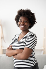 Portrait of smiling african american woman with crossed arms and casual clothing.