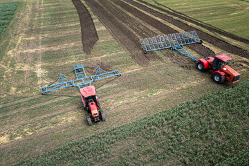 Agriculture machine harvesting crop in fields. Tractor pulls a mechanism for haymaking. Harvesting in autumn in morning at dawn. agribusiness in the Altai region Russia. aerial view from above