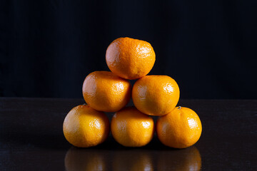 There are tangerines on the table. which lie one on top of the other.
