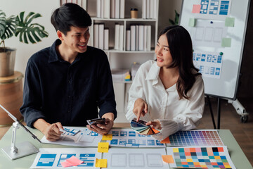 Fototapeta premium young husband and wife working at office by new project and happy