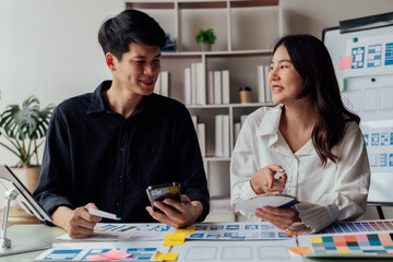 Fototapeta premium young husband and wife working at office by new project and happy
