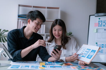 Fototapeta premium young husband and wife working at office by new project and happy