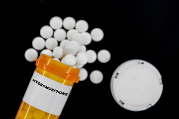 Hydromorphone Rx medical pills in plactic Bottle with tablets. Pills spilling out from yellow...