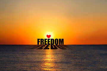 Freedom. Word on the background of the sunset over the ocean. Concept of freedom. Lifestyle.