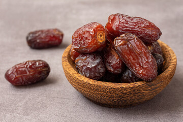 delicious dried dates in a wooden bowl.