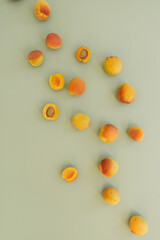 Flat lay composition with ripe peaches on neutral green background