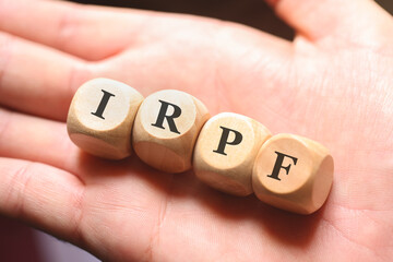 A sigla IRPF para Imposto sobre a Renda das Pessoas Físicas escrita em dados de madeira. Imposto de Renda no Brasil. - obrazy, fototapety, plakaty
