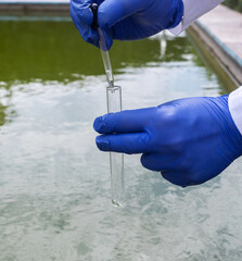 Water sample. Treatment facilities. Quality control of water that has been purified and processed. The laboratory assistant collects material for research. Liquid in a test tube. Sewage treatment