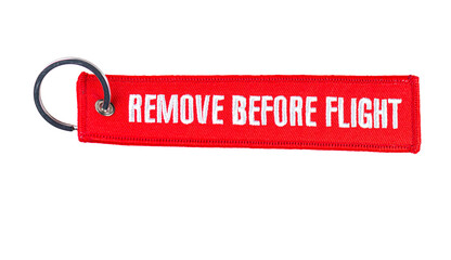 Trinket Remove before flight - warning tag. It is a safety warning seen on removable aircraft