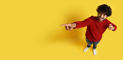 Top view of indian guy pointing at copy space