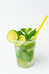 Vertical shot of a fresh lime lemonade in a to go plastic glass with mint.