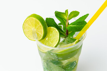 Close up shot of a fresh lime lemonade in a to go plastic glass with mint.