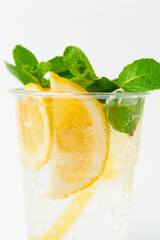 Vertical shot of a fresh lemonade in a to go plastic glass with mint leaves.